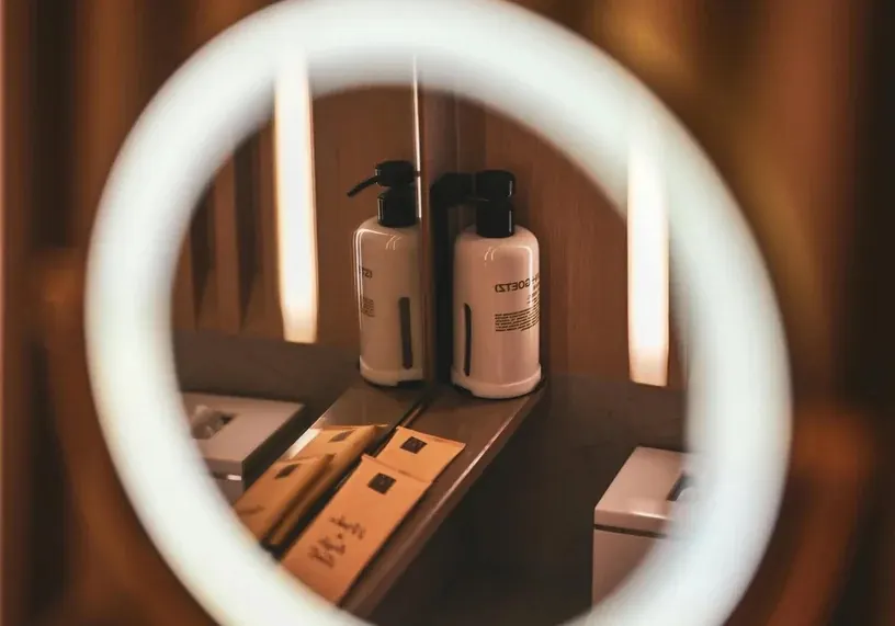 Productos cosméticos frente a un espejo con aro de luz